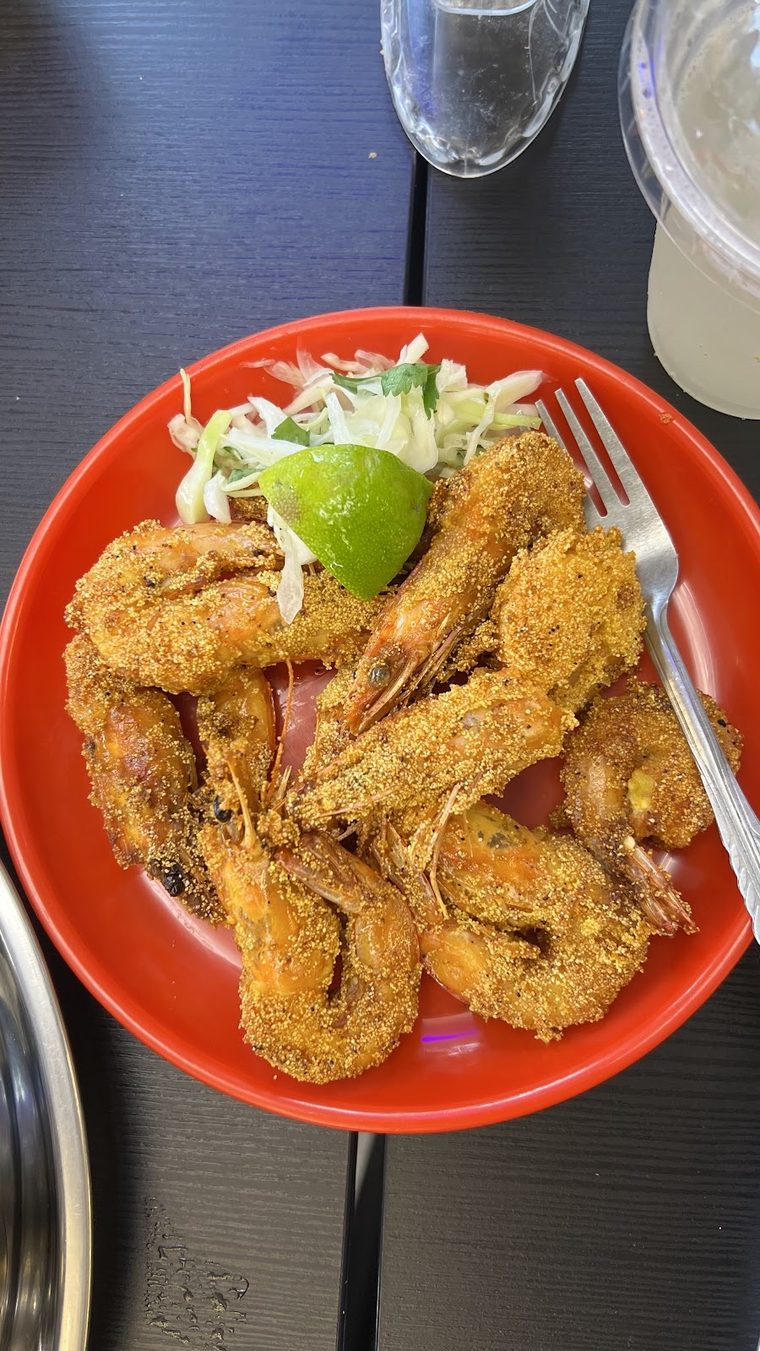 Crumbed fried prawns with salad and lime