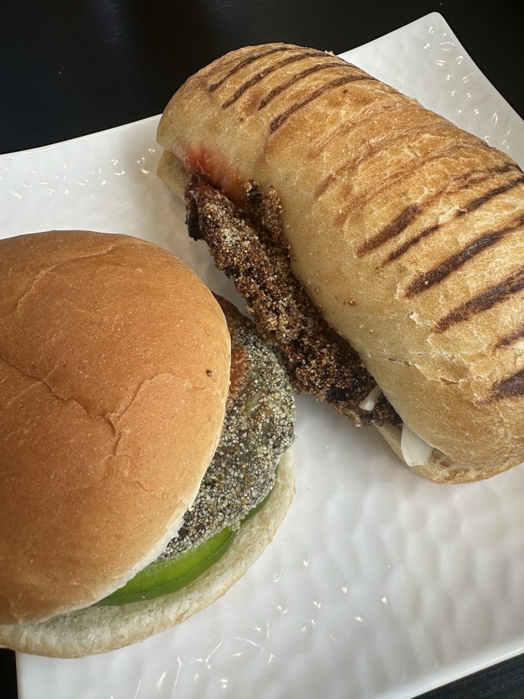 A griddled ciabatta sandwich and a burger with green chilli